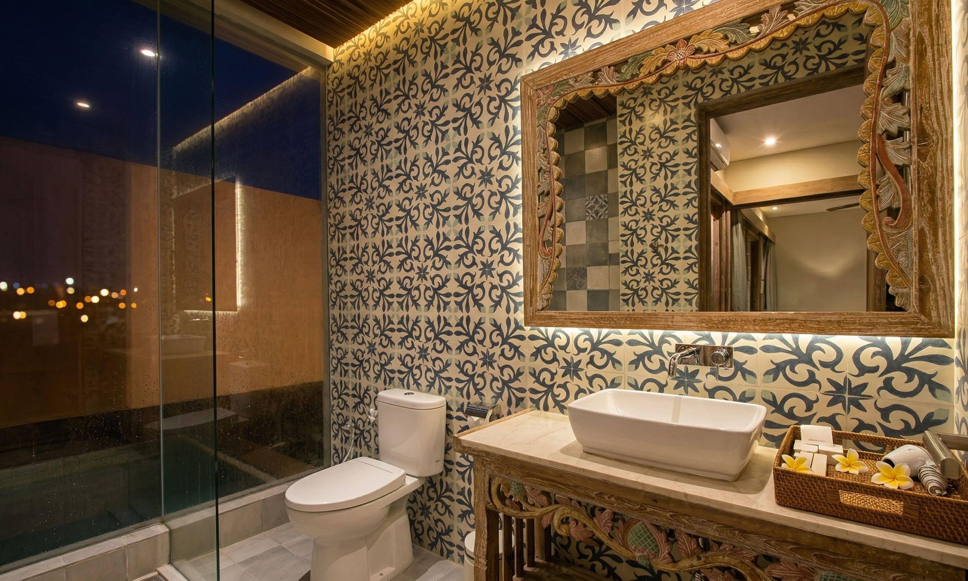 Une salle de bain équipée de toilettes, d’un lavabo et d’un miroir décoratif.
