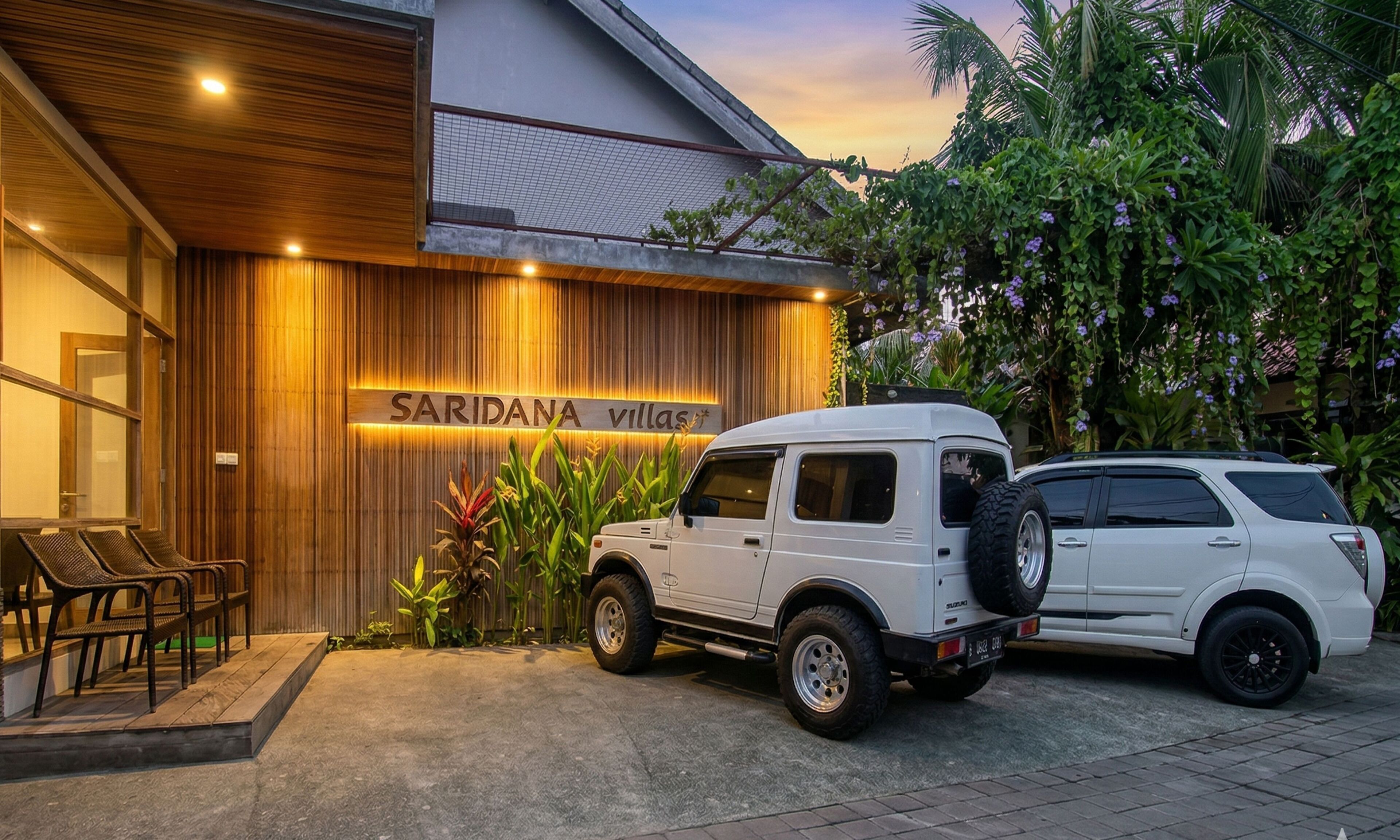 A white SUV parked in front of a building with a sign reading 'SARIDANA villas'.