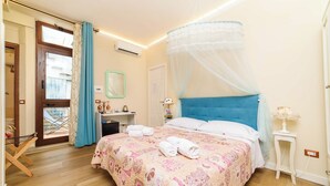 Une chambre à coucher avec un lit, une fenêtre avec des rideaux, une table de chevet et un climatiseur fixé au mur.