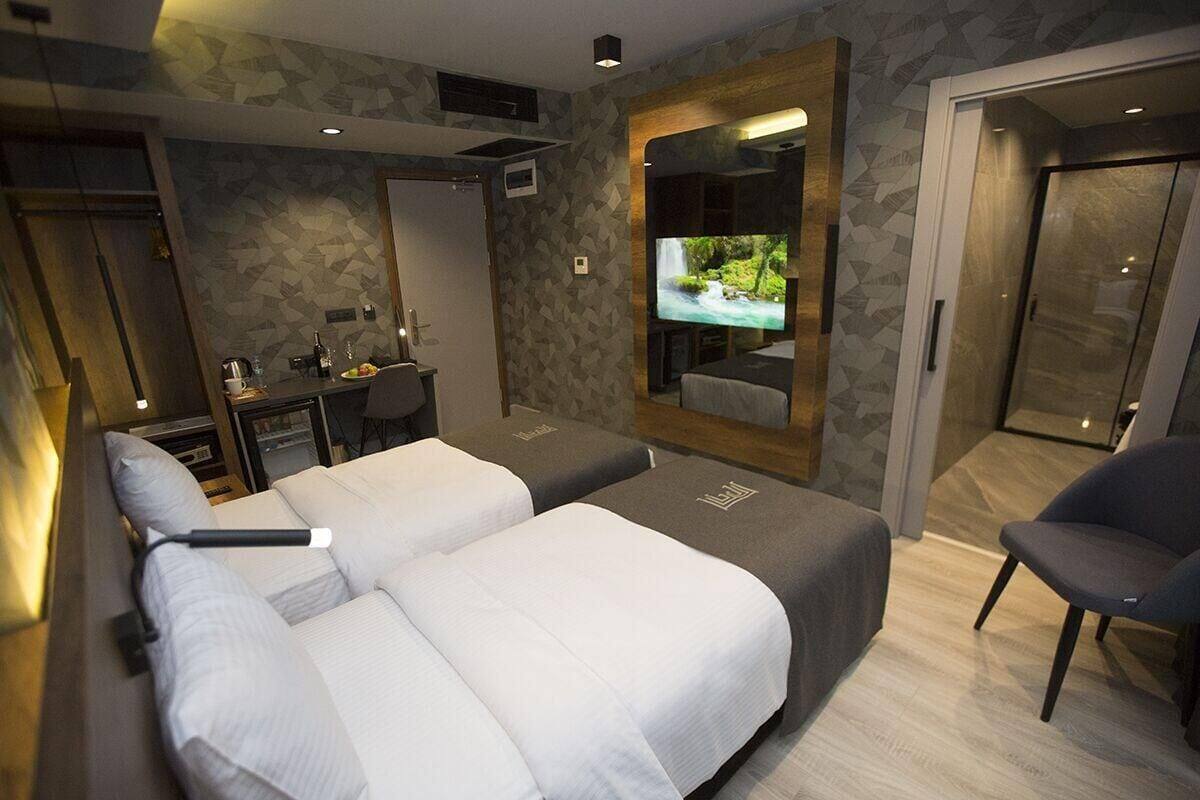Una habitación de hotel moderna con una cama grande, un televisor, un escritorio y una silla.