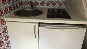 Een kleine keuken met een spoelbak, een vaatwasser en een koelkast.