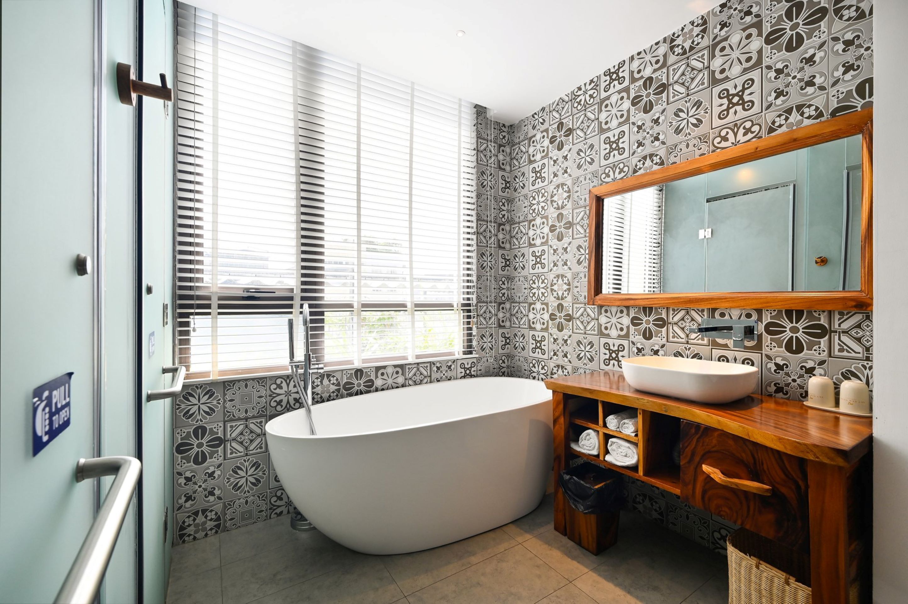 Une salle de bain moderne avec une baignoire sur pieds, un meuble-lavabo en bois et un grand miroir.