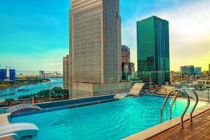 Piscina com vista para edifícios altos e um rio.