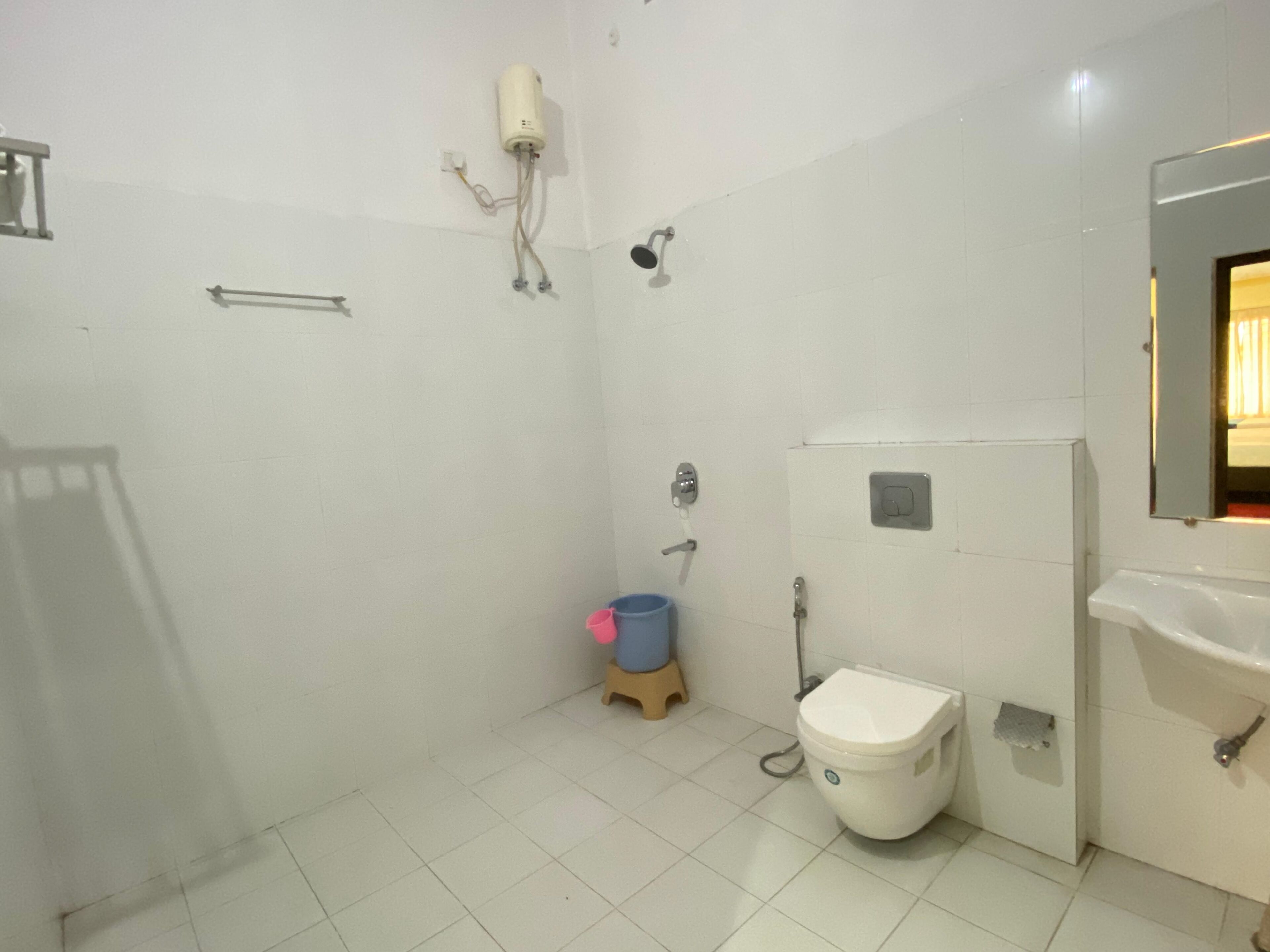 A small bathroom with a toilet, a sink, and a shower.