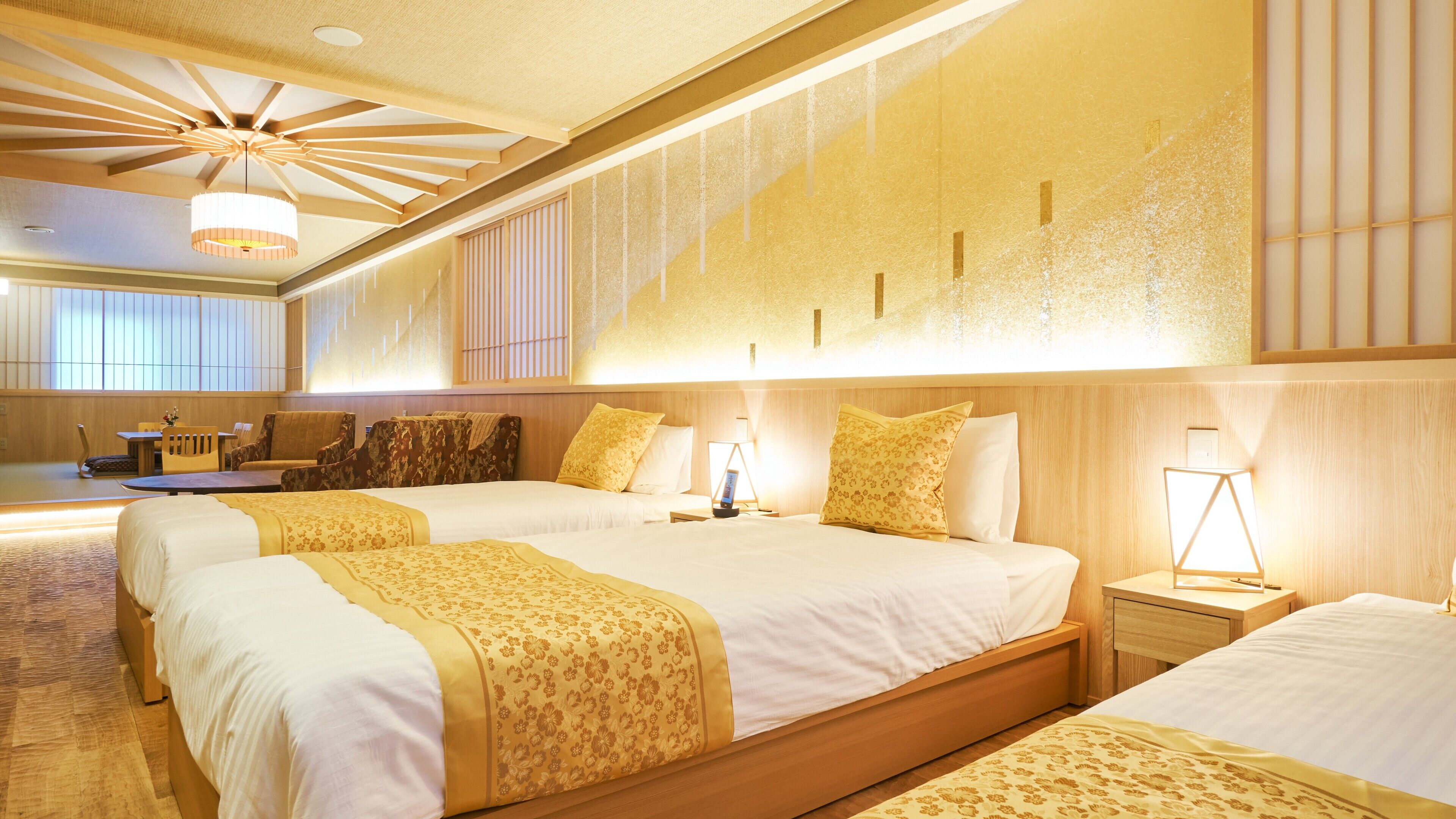 Quarto de hotel com uma cama grande, mesas de cabeceira, escrivaninha e uma cadeira.