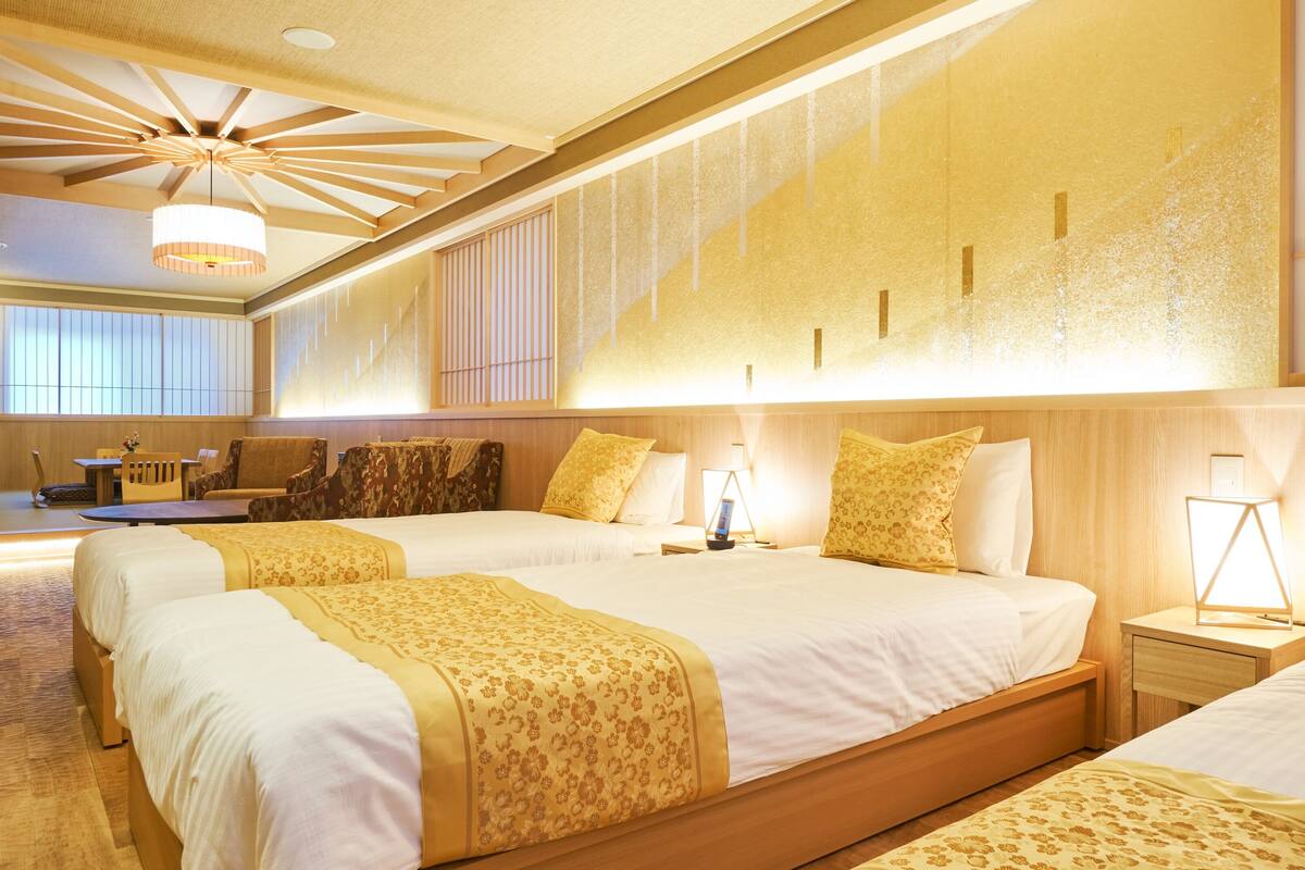 A hotel room with a large bed, bedside tables, a desk, and a chair.