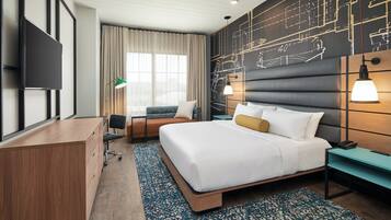 A modern hotel room with a large bed, a desk, a chair, a TV, and a wall with a blueprint design.