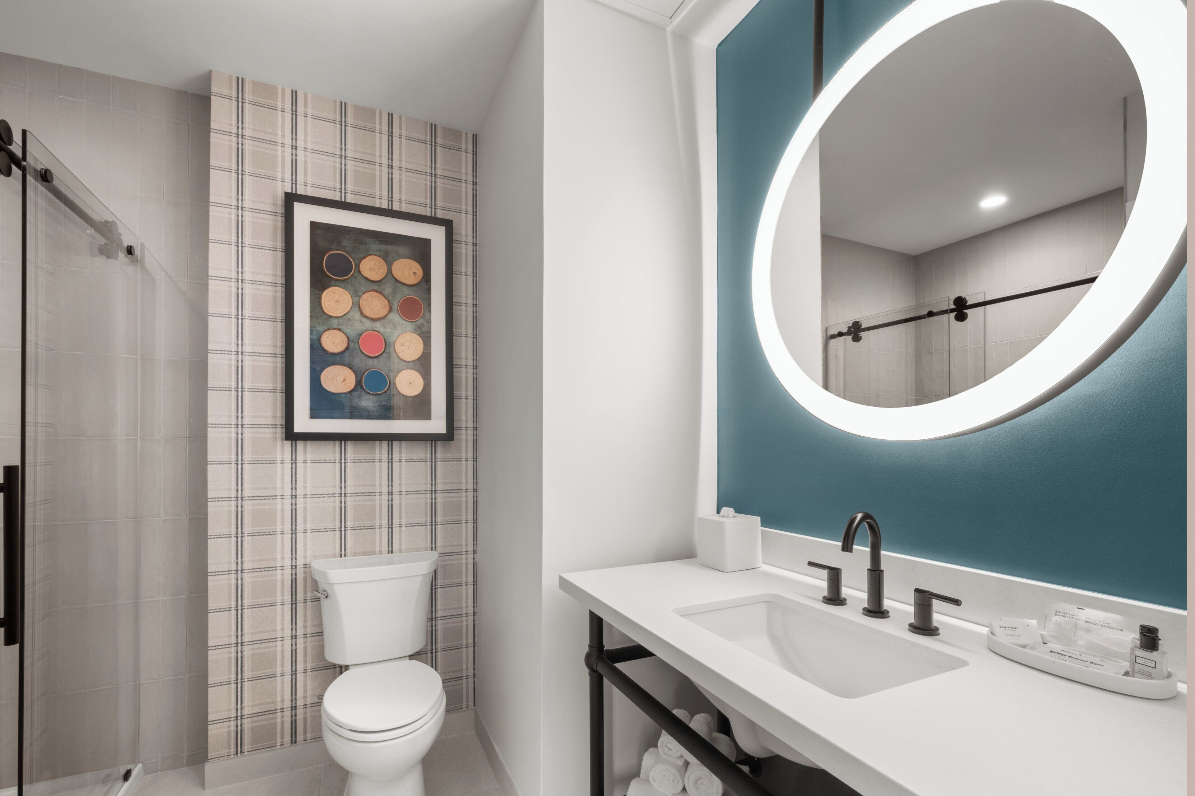 Et moderne badeværelse med toilet, brusebad, vask og spejl.
