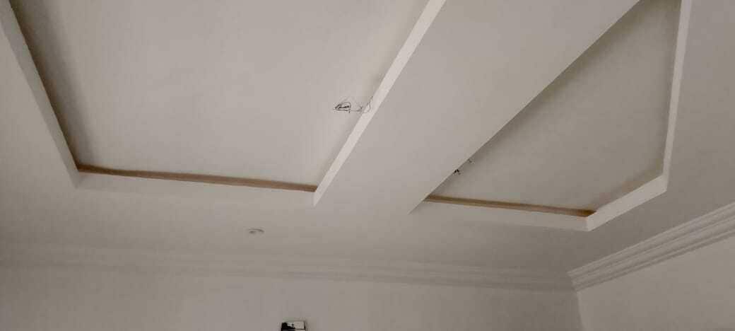 A room with a plain white ceiling and a visible wooden beam.