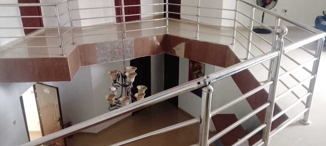 A multi-level interior with a staircase, metal railings, and a chandelier.