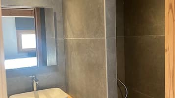 Une salle de bain avec un meuble-lavabo en bois, un lavabo blanc et un miroir.