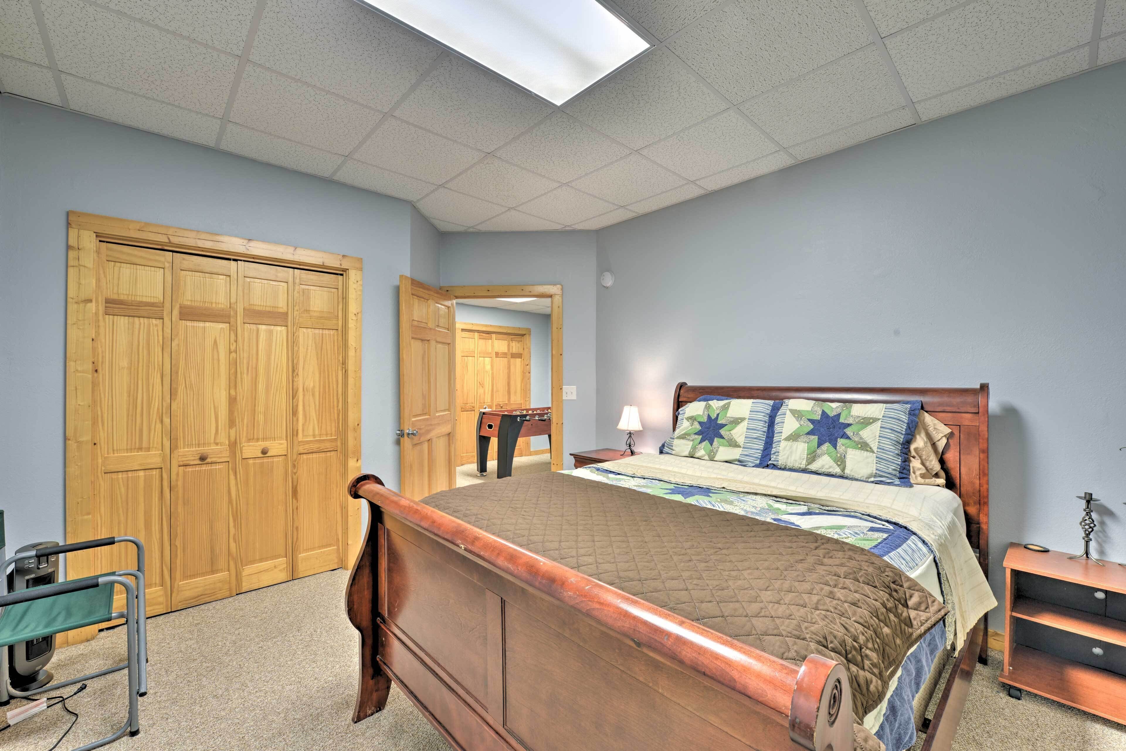 Un dormitorio con una cama de madera, una mesita de noche, una lámpara y un armario de madera.
