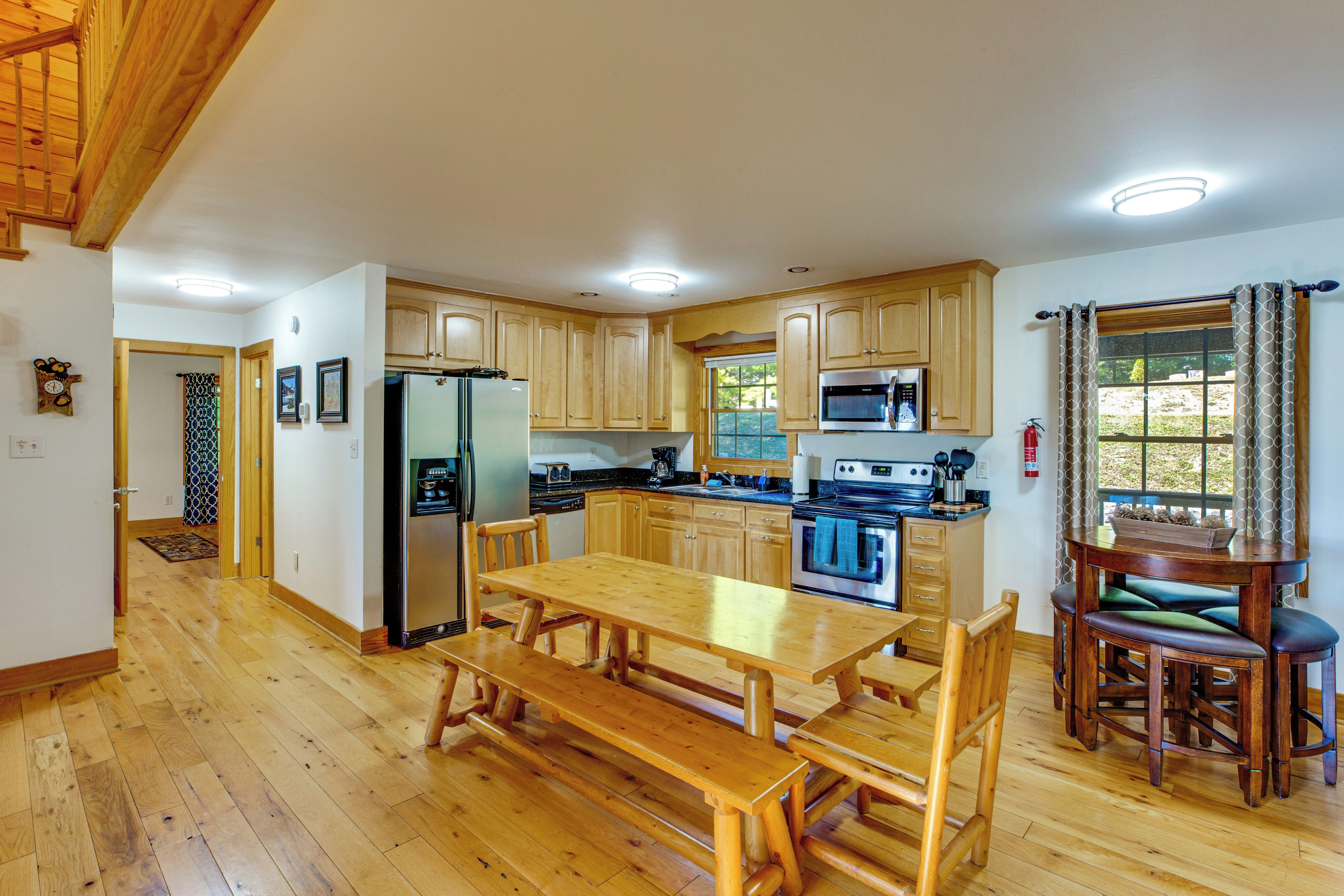 A spacious kitchen with wooden cabinets, a large dining table, and a built-in oven.