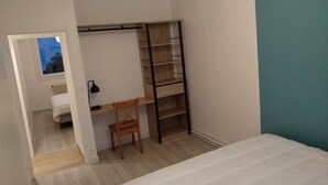 Una camera da letto con un letto, una scrivania, una sedia, un armadio e una finestra.