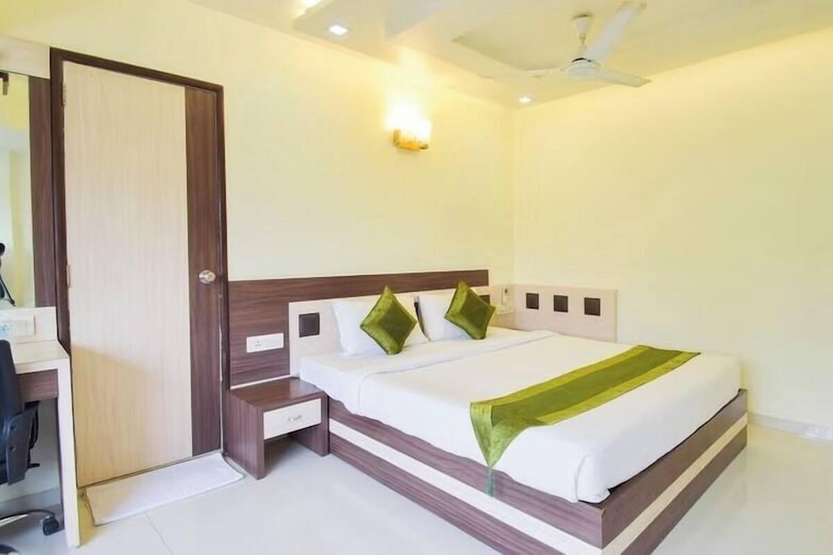 A bedroom with a bed, bedside table, and a wardrobe.