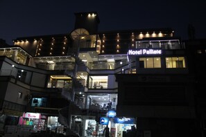 Vista frontal de la propiedad por la tarde o noche