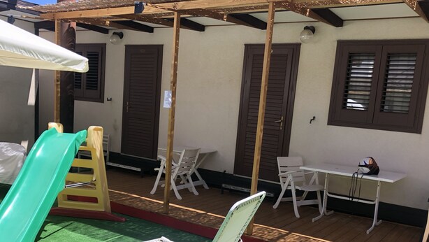 Un'area esterna riparata con uno scivolo, posti a sedere e un tavolo.