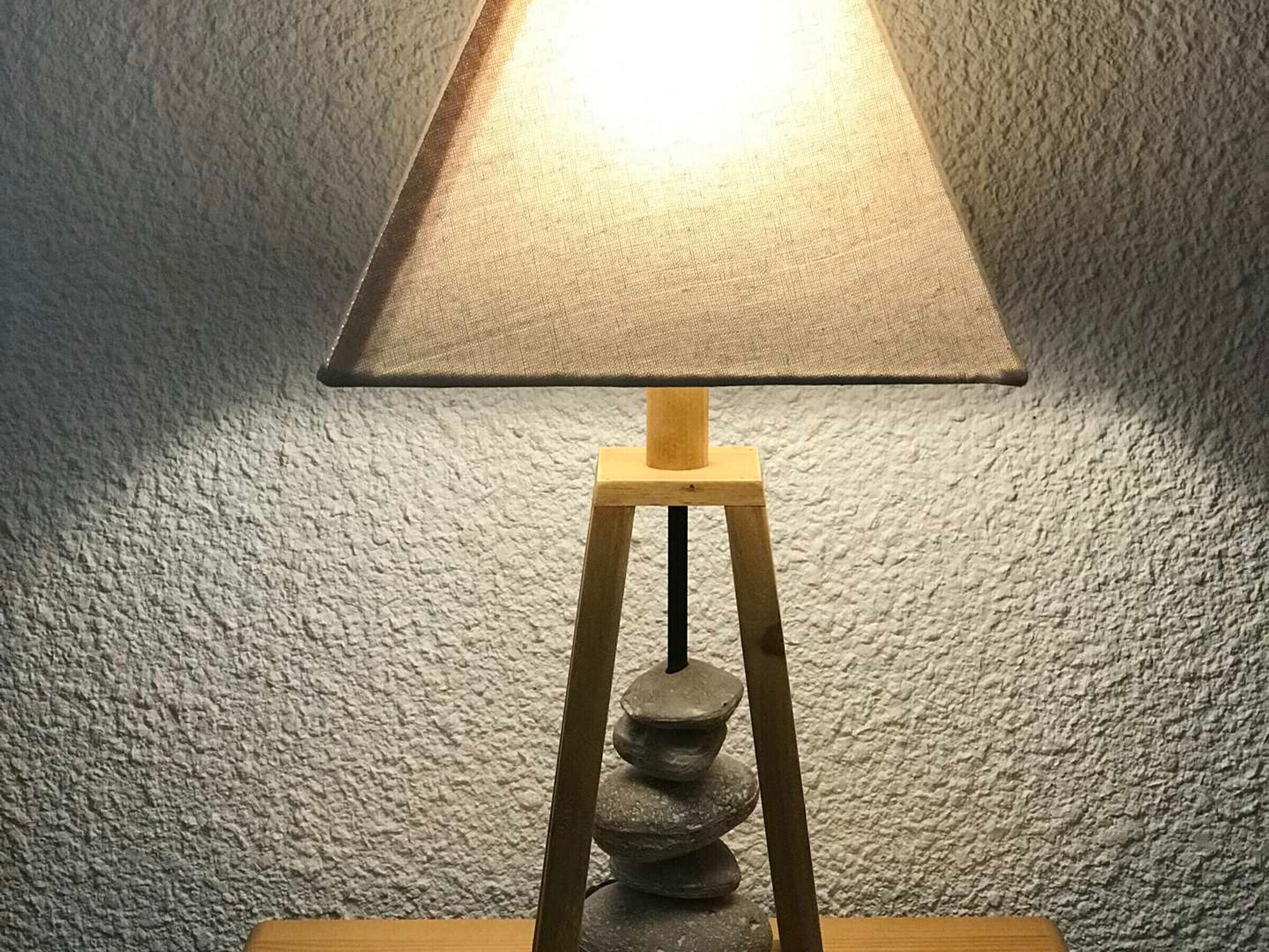 A lamp with a wooden base and a textured lampshade.