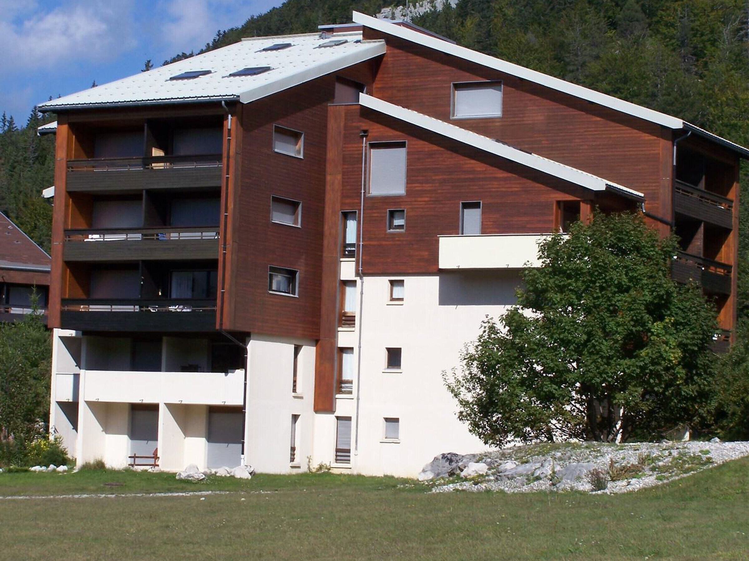 A multi-story building with a modern design, featuring balconies and large windows.