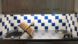 A kitchen with wooden cabinets, a tiled backsplash, a sink, and a stove. - Studio at slopes, south-facing balcony (Corrençon-en-Vercors)