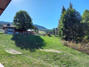 A rural landscape with a stone building, a large tree, and a mountain in the background. - 2-room apartment for 6 near slopes with WiFi and parking (Les Arcs 1800)