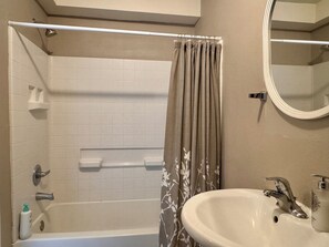 Tina con regadera, toallas, jabón, shampoo 