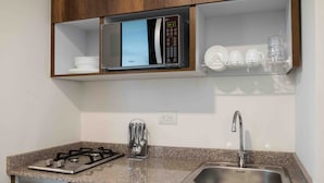 A compact kitchen with a built-in microwave, a stainless steel sink, and a gas stove. - Altoprado Popayán (Popayán)