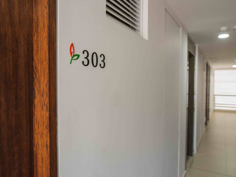 A hallway with a number sign '303' on the wall, indicating a room number.