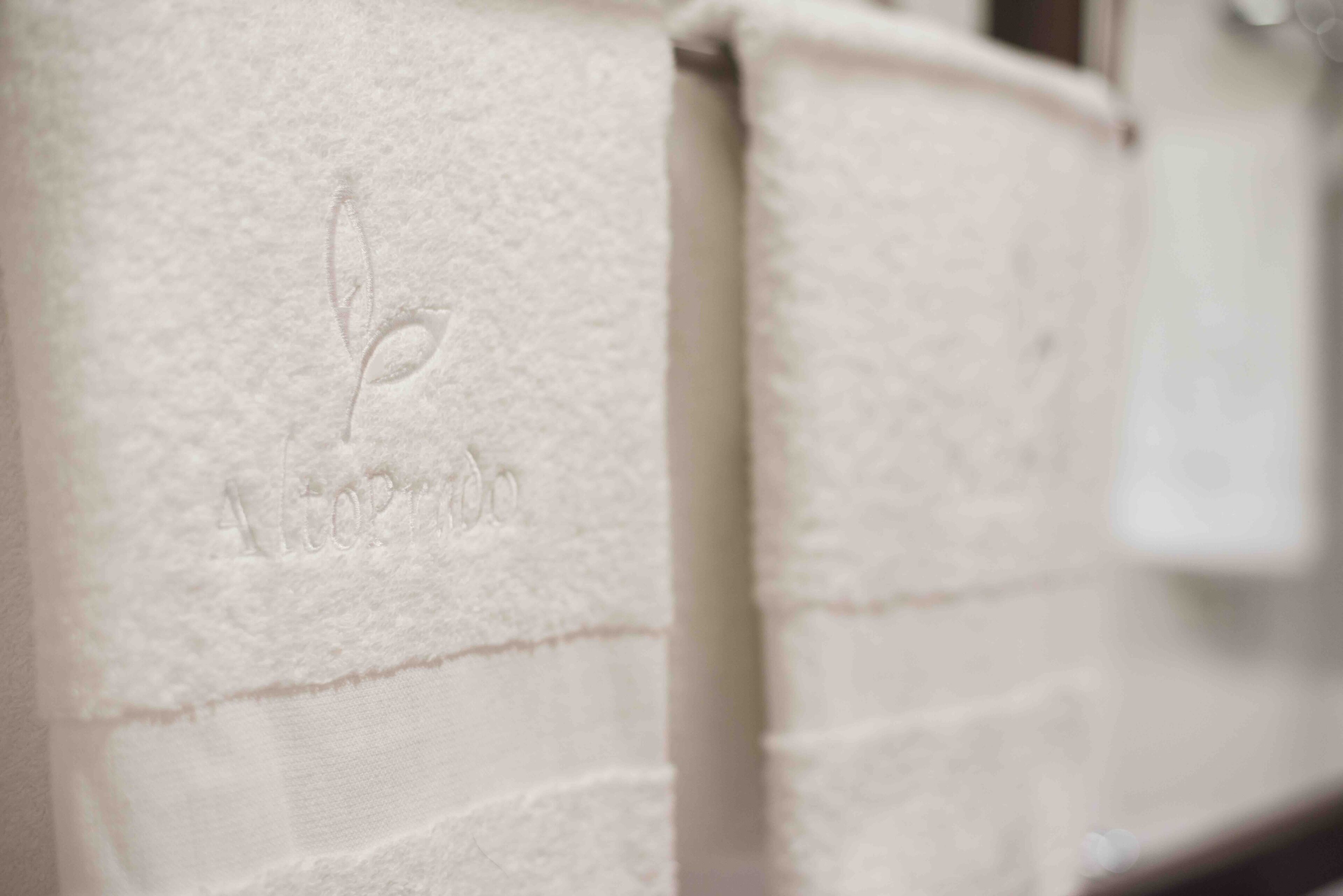 A close-up of a white textured wall with a subtle embossed logo.