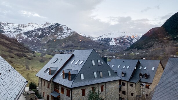 A stone building with multiple roofs and a valley view. - Baqueira 3 room, 4 cw spectacular duplex with parking for 6-8 people (Baqueira)