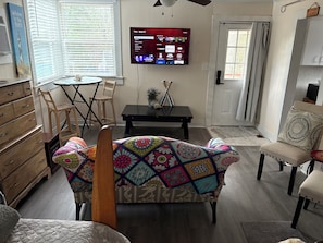 Relax in this inviting living room with a sofa, flat-screen TV, and dining area.