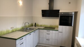 A modern kitchen with a sink, stove, and cabinets.