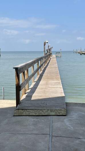 A wooden pier extending into calm waters, with a concrete platform at the end. - Sunset Cove-4 BR, 2 1/2 BA Waterfront Home. Sleeps 12-Private pier! (Rockport)