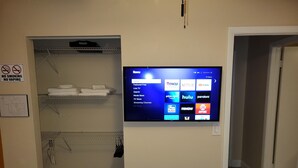 Une chambre d’hôtel équipée d’un téléviseur à écran plat fixé au mur et affichant l’interface Roku.