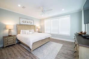 A bedroom with a large bed, two bedside tables, a ceiling fan, and a window with blinds. - Short walk to Beach - Pool -Sleeps 8 Wifi (Gulf Shores)