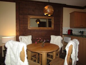 Enjoy meals in this inviting dining area with a round table and four chairs, a mirror, and a unique pendant light.