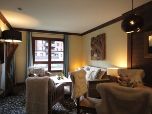 Relax in this inviting room with a sofa, throw blanket, and a view of the outside through the window.