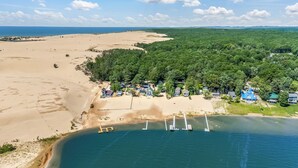 A coastal area with a beach, forest, and several houses. - Lake frontage, Dune beach sand from deck to water! One of a kind. (Mears)