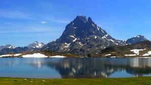 A mountain landscape with a lake reflecting the peaks. - HOLIDAY IN QUIET AT THE MOUNTAIN (Issor)