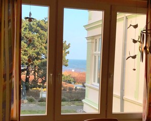 A room with a view of the ocean through large windows.