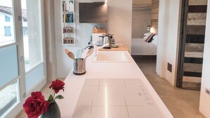 Una cocina moderna con una isla central, un comedor con cama y vistas al exterior.