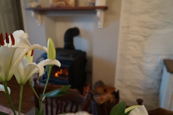 A room with a fireplace, a wooden shelf above it, and a white textured wall. - Mulranny House Bed & Breakfast (Mulranny)