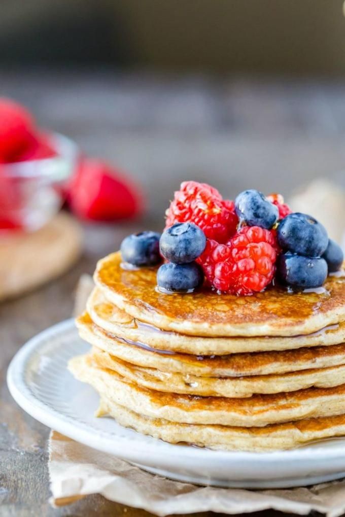 A stack of pancakes with berries on top.