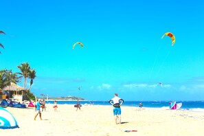 A beach with people, tents, and kites. - KiteBeach Agualina Oceanfront Condo Complex in Hotel (Cabarete)