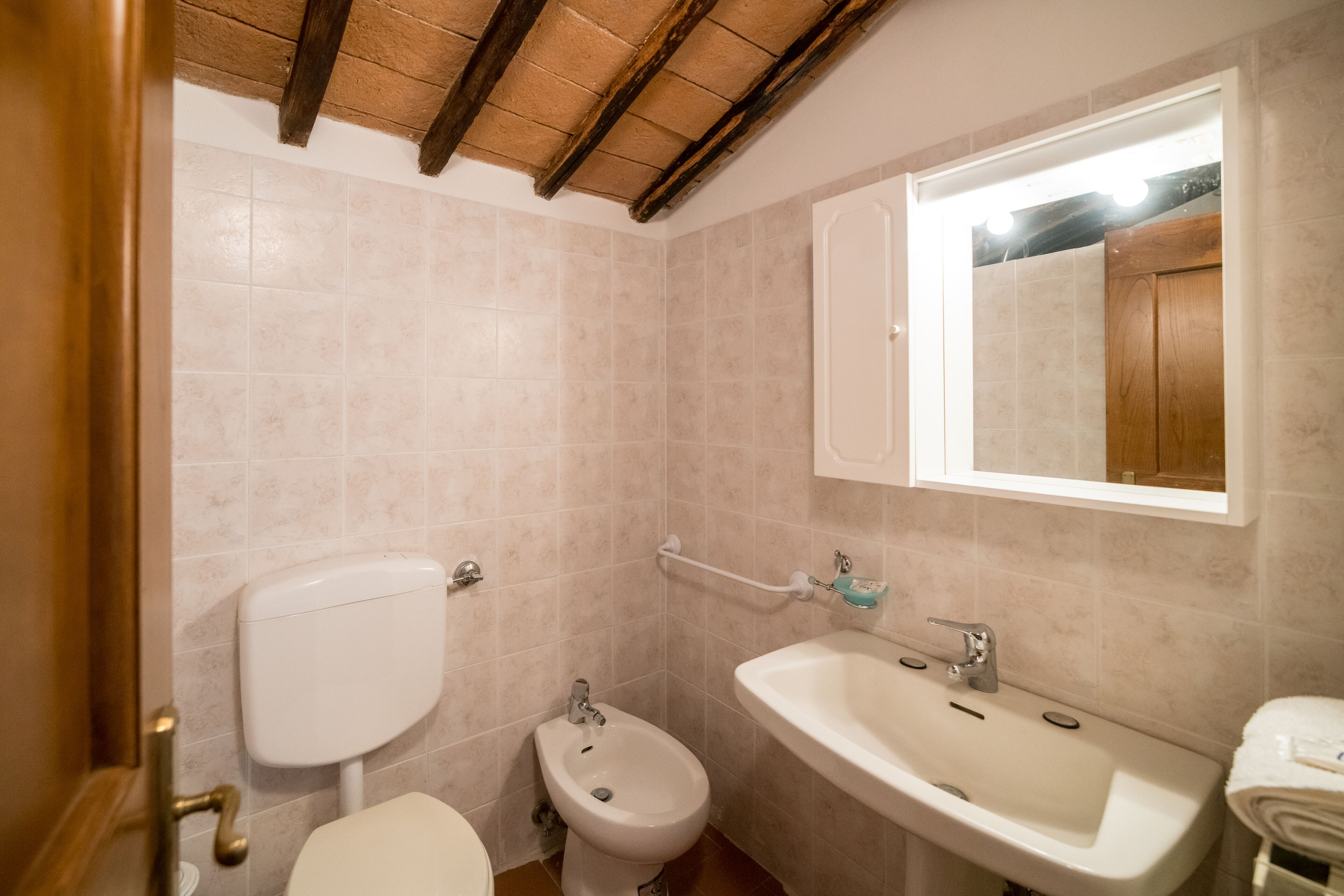 Ein Badezimmer mit Toilette, Bidet, Waschbecken und Spiegel.