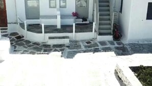 Um edifício branco com uma escadaria que leva a uma varanda.