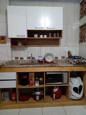 Compact kitchen with central island, sink, and microwave, offering ample storage and utility.