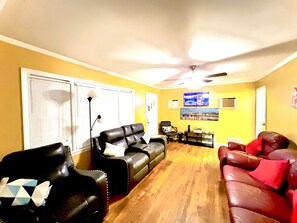 A living room with a sofa, chairs, a TV, and a ceiling fan. - [Quite Oasis~4]5bds]1.5BT]3BR@Stockbridge GA (Stockbridge)
