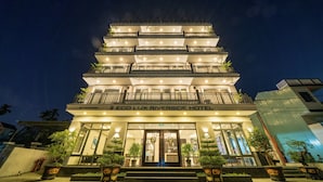 A multi-story hotel with a modern design, featuring balconies on each floor and a well-lit entrance. -  Eco Lux Riverside Hotel & Spa (Da Nang)
