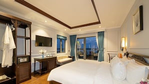 A hotel room with a large bed, a vanity with a mirror, a seating area with a view, and a balcony. -  Eco Lux Riverside Hotel & Spa (Da Nang)